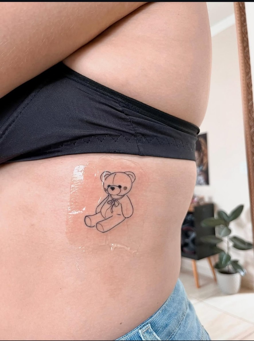 Tatuagem fine line de ursinho na costela
